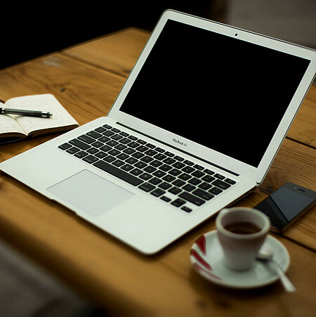 Schreibtisch mit Laptop und einer Tasse Kaffee