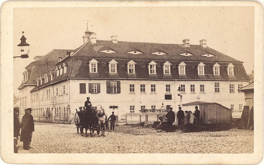 Bernhard Sparmeyer: Gemeinhaus von 1724 mit Zisterne und Platz-Buden. Fotografie, ca. 1870.